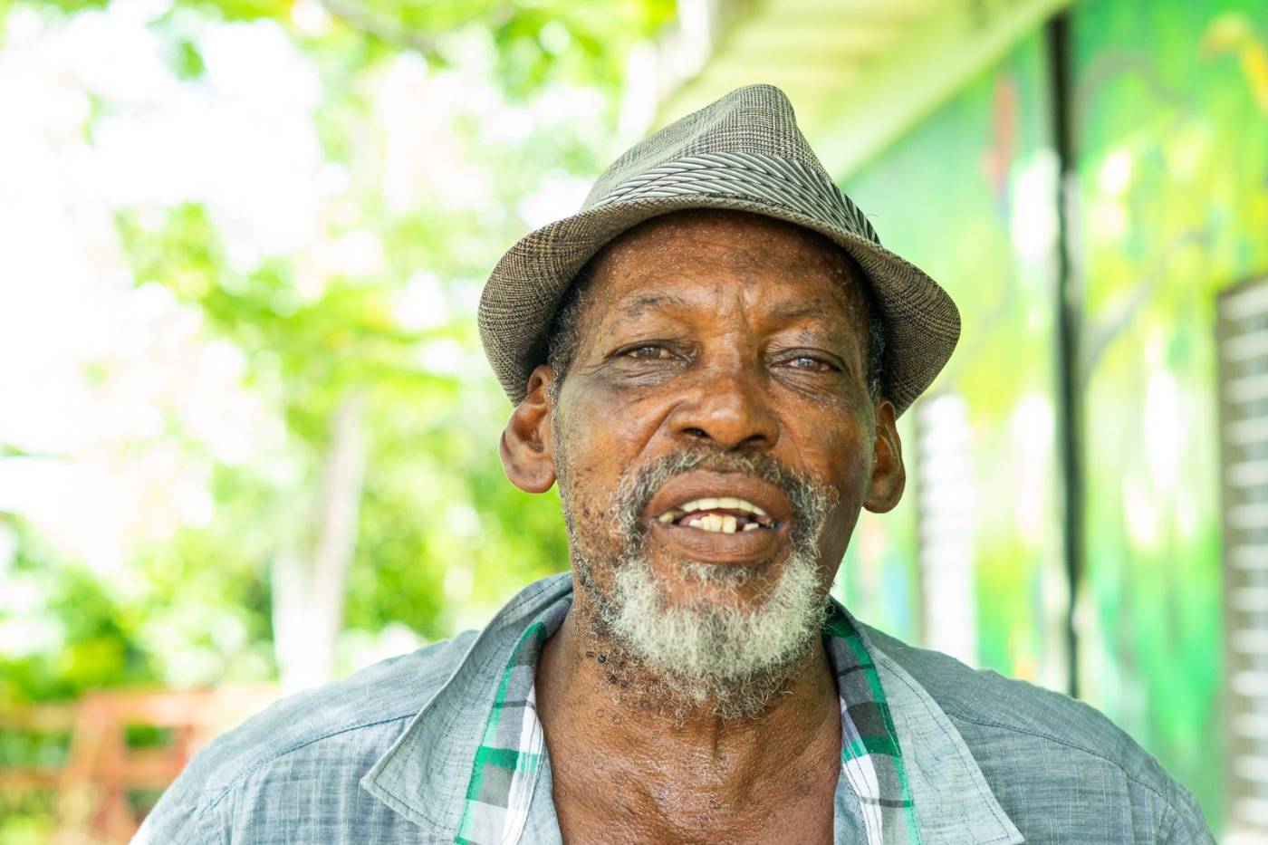 A smiling older man in a brimmed hat in Belize's Cayo District