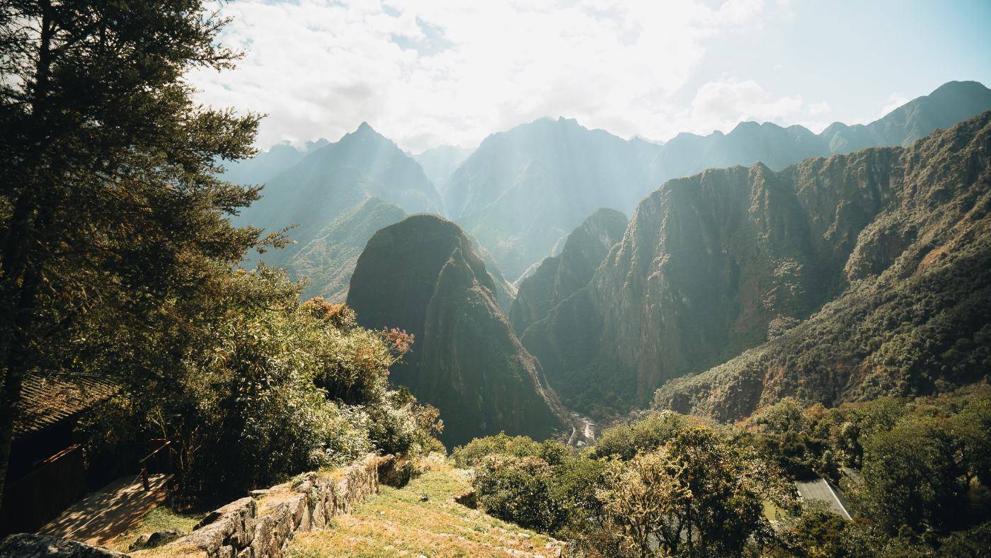 Sunlight breaking through the steep green peaks of the Urubamba canyon below Machu Picchu