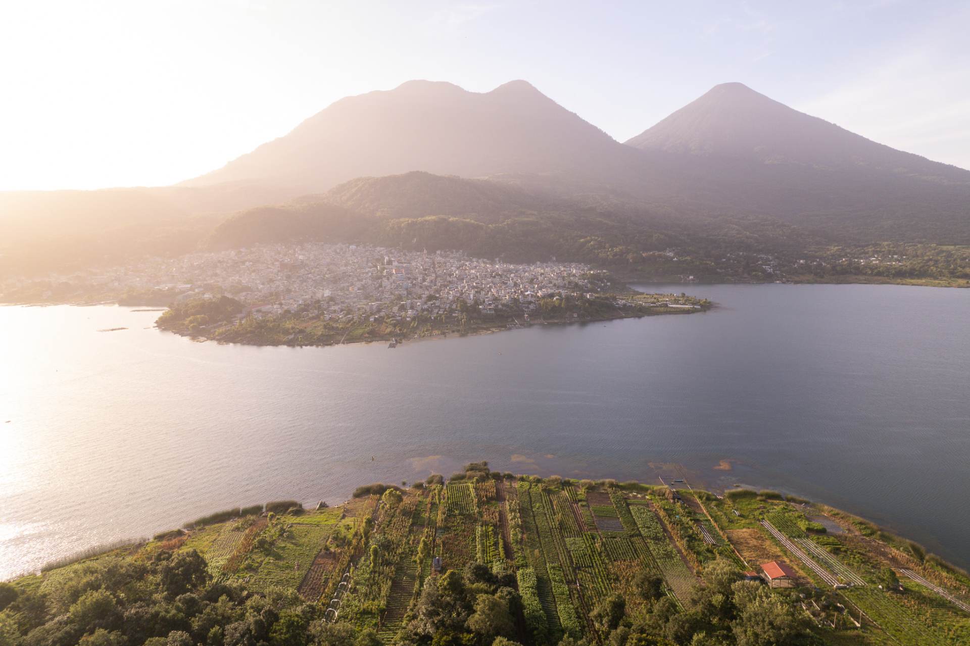 Aerial view of a lakeshore town and farm plots on Lake Atitlán
